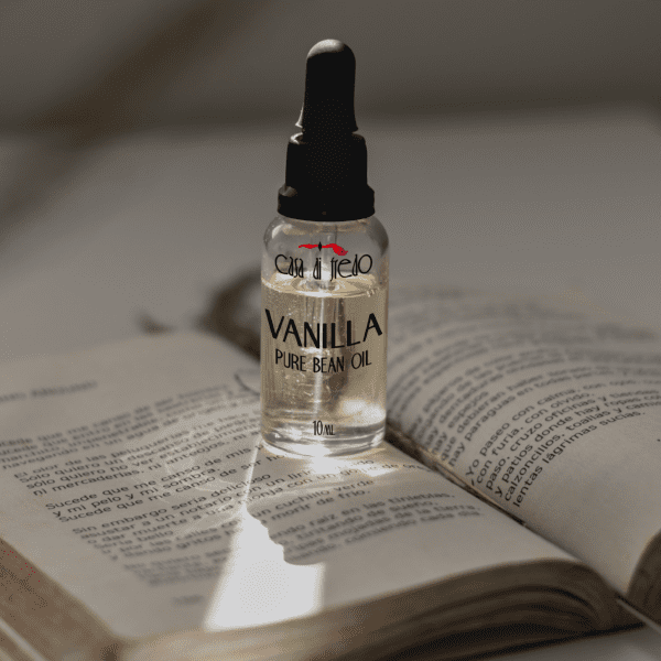 Vanilla bean oil bottle on open book.