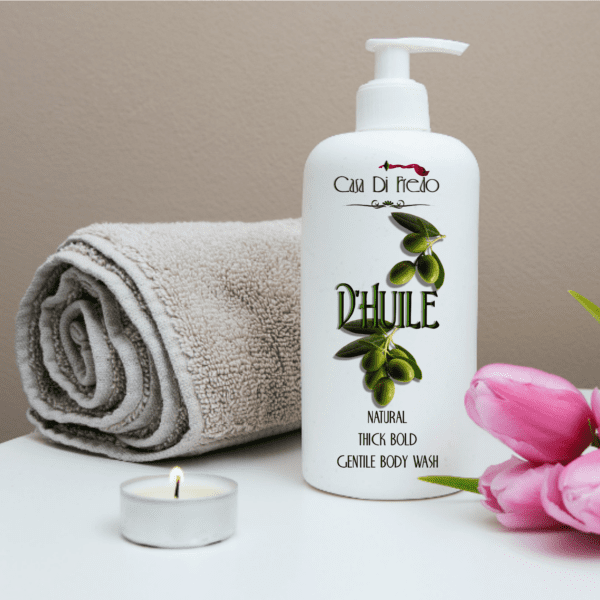 Olive oil body wash bottle with towel and candle.