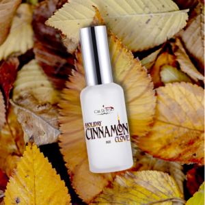 Holiday cinnamon clove fragrance bottle on leaves.