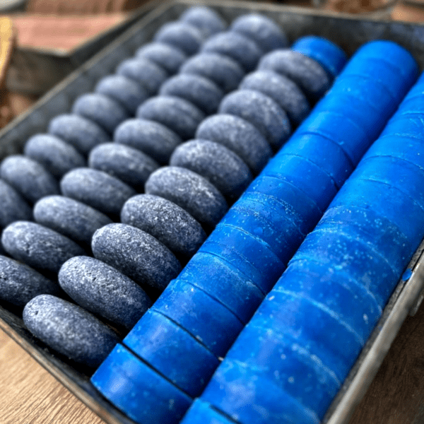 Grey stones and blue cylindrical objects in a tray.