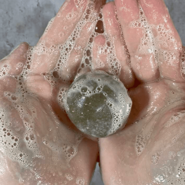 Soapy hands with a green bar of soap.